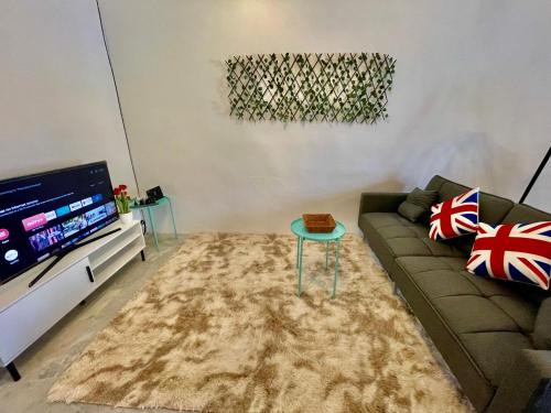 a living room with a couch and a flat screen tv at Home41#4pax#Netflix#NearAeonAlma#BM#5kmtoIconicPoint in Bukit Mertajam