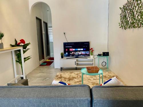 a living room with a couch and a tv at Home41#4pax#Netflix#NearAeonAlma#BM#5kmtoIconicPoint in Bukit Mertajam