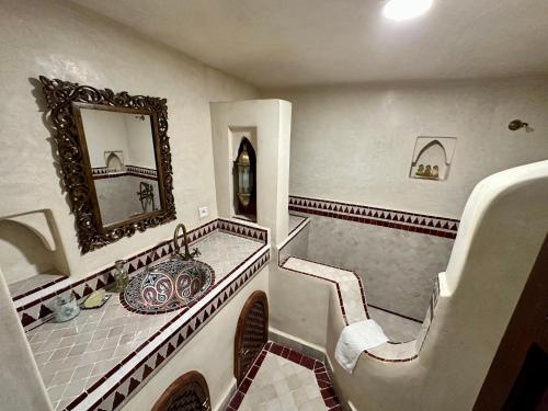 a bathroom with a tub and a sink and a mirror at Riad Sakura Marrakech in Marrakesh