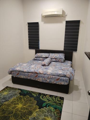 a bedroom with a bed and a rug at Lekir baiduri homestay in Sitiawan