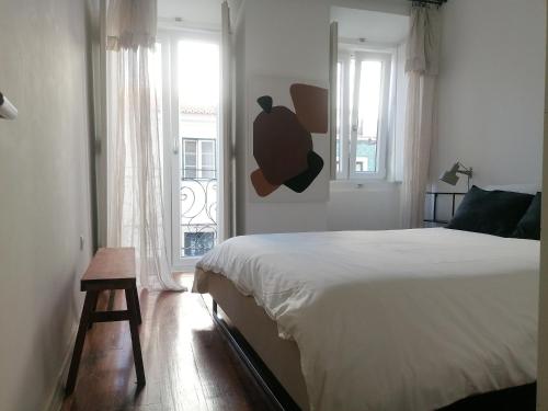 リスボンにあるCasa com Jardim privadoのベッドルーム(白いベッド1台、窓付)
