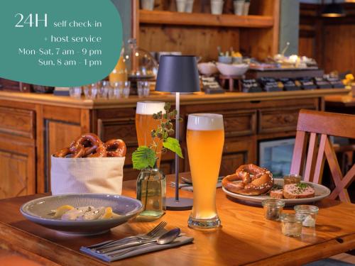 Una mesa con dos vasos de cerveza y pretzels. en Classik Hotel Martinshof, Messe München, en Múnich