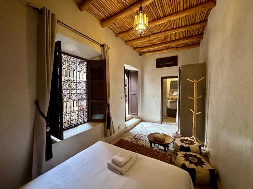 um quarto com uma cama e uma grande janela em Riad Sakura Marrakech em Marraquexe