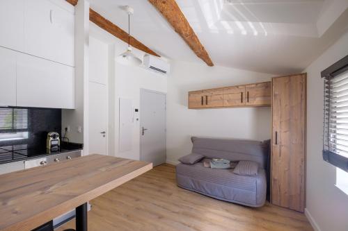 - une cuisine avec une table et un canapé dans une chambre dans l'établissement Joli Studio Champagne au Mont d'or, à Champagne-au-Mont-dʼOr