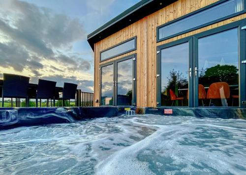 a house with a swimming pool with snow at Forest Hills Lodges in Coleford