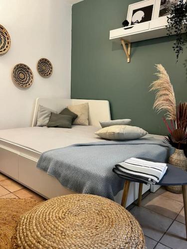 - un lit blanc avec des oreillers et une table dans la chambre dans l'établissement Aix-en-Provence, Cosy Studio proche toutes commodités, linges fournis, à Aix-en-Provence