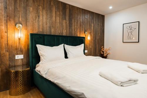 1 dormitorio con 1 cama grande y pared de madera en Rope Street eState Picturesque en Brasov