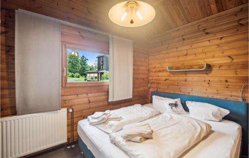 a bed in a wooden room with a window at Amazing Home In Oberharz With Kitchen in Waldschlösschen