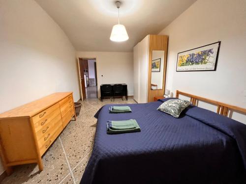 ボルゴ・ア・モッツァーノにあるAppartamento Gaylenのベッドルーム(青いベッド1台、木製ドレッサー付)