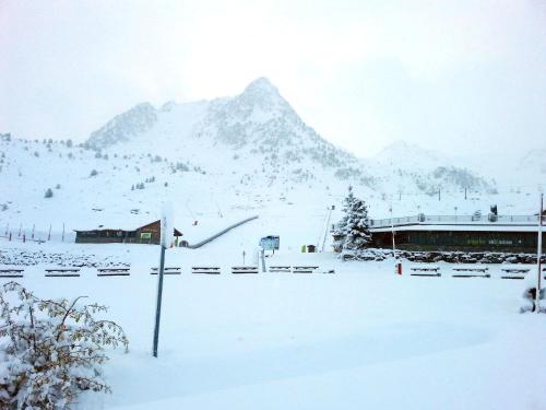 a snow covered field with a mountain in the background at Snö Hotel Formigal in Formigal