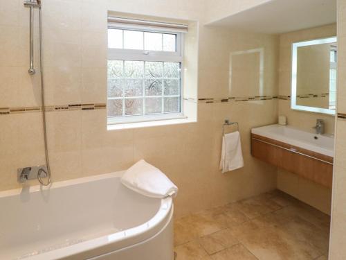 a bathroom with a tub and a sink at Woodland Lodge in Boston