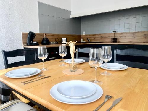 una mesa de madera con platos y copas de vino. en *Chic & Basic T3* place Carnot, en Carcassonne