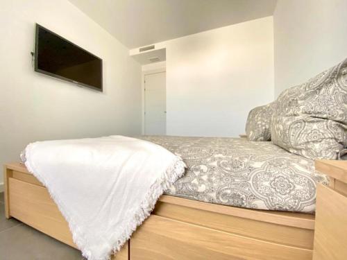 - un lit avec une couverture blanche dans l'établissement NEREA Rota Apartment by Cadiz4Rentals, à Rota