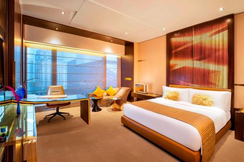 Pokój hotelowy z łóżkiem, biurkiem i biurkiem w obiekcie W Guangzhou w Guangzhou