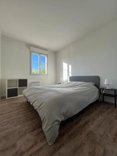 Un dormitorio blanco con una cama grande. en F3 pour 4-6 pers centre-ville Plaisir avec parking, en Plaisir