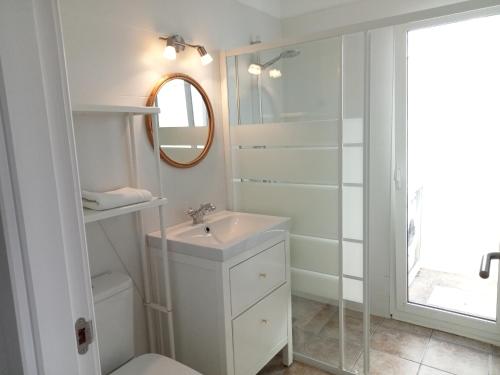 a white bathroom with a sink and a mirror at Quintero Suites in San Bartolomé