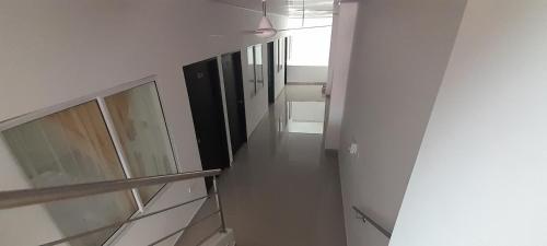 a hallway with white walls and a stairway in a building at Hotel Apartado Real in Apartadó