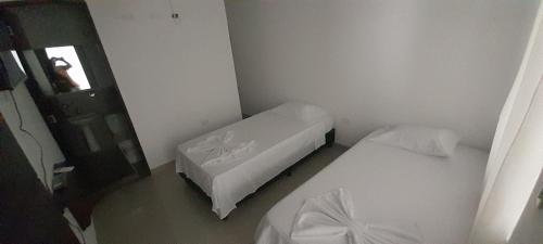 um pequeno quarto com 2 camas e um espelho em Hotel Apartado Real em Apartadó