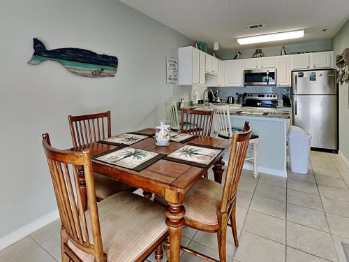 a kitchen with a table and chairs and a kitchen with a refrigerator at Grand Caribbean Perdido Key #306 West in Perdido Key