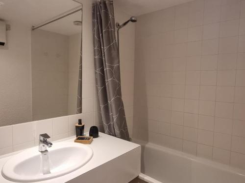 une salle de bain avec un lavabo et un rideau de douche dans l'établissement Studio lumineux au pied des pistes avec balcon exposé Sud - FR-1-181-2568, à Aime La Plagne