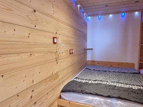 - une chambre avec un lit dans un mur en bois dans l'établissement Studio Plagne Aime 2000, 2 pièces, 4 personnes - FR-1-181-2579, à Aime La Plagne