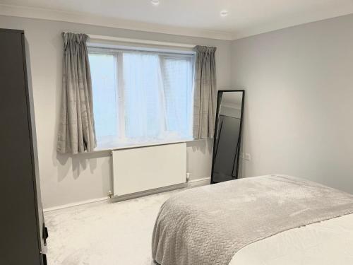 a bedroom with a bed and a window and a mirror at Lovely 1 bed apartment, 15mins from Central London in London