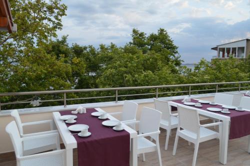 a white table and chairs on a balcony at Ada Palas Otel in Marmara Adasi