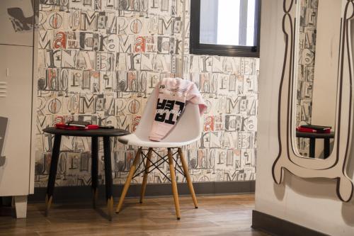 a white chair with a sweater on it in a room at room00 Ventura Hostel in Madrid