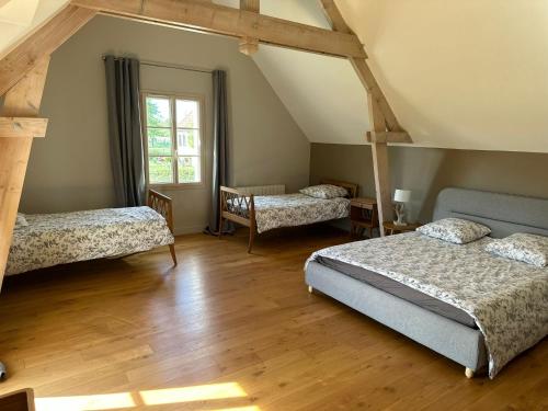 une chambre avec trois lits et une fenêtre dans l'établissement Comtesse Mahaut - Gîte de Charme - Les Bastides d'Edouard en Bourgogne, à Mailly-le-Château
