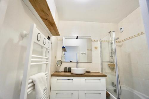 une salle de bain blanche avec un lavabo et une douche dans l'établissement La Vigie, à Concarneau