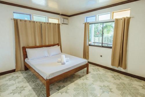 a bedroom with a bed and a window at Casa Ella in General Luna