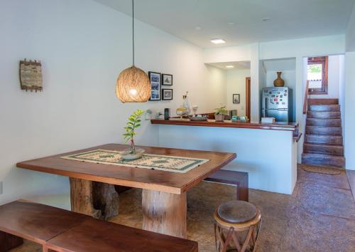 a dining room with a table and a refrigerator at Casa Canoa Camocim in Camocim