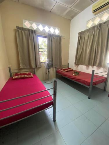 Cette chambre comprend 2 lits et une fenêtre. dans l'établissement Homestay Bukit Awi, à Kulim