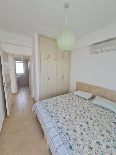 a bedroom with a large bed and a light at Penthouse with rooftop terrace in Akanthou