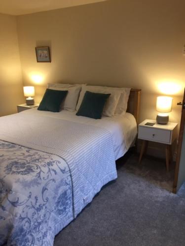 a bedroom with a large bed with two lamps on it at Rock View in Froggatt