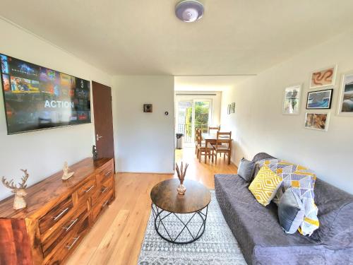 ein Wohnzimmer mit einem Sofa und einem Tisch in der Unterkunft Tranquil Home Away from Home in Newton Mearns