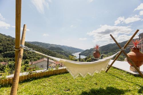 a hammock on a hill overlooking a valley at Quinta Flor de Lis, Gerês in Vieira do Minho