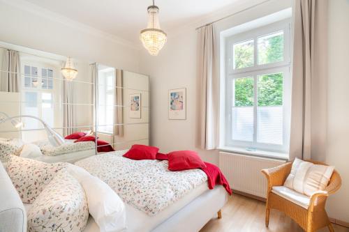 - une chambre avec 2 lits, une chaise et des fenêtres dans l'établissement Villa Carmen, à Bansin