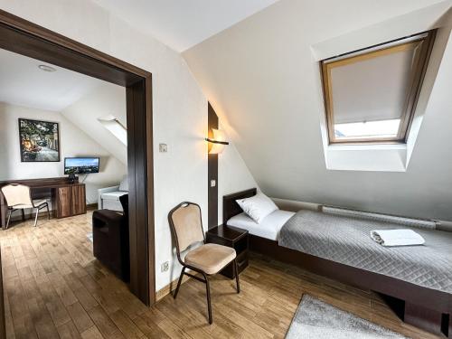 a small room with a bed and a window at Hotel Mieszko in Rzeszów
