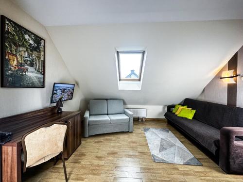 a living room with a couch and a chair at Hotel Mieszko in Rzeszów