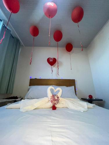 a room with red balloons and a bed with red hearts at Hotel Olam Confort in Villavicencio