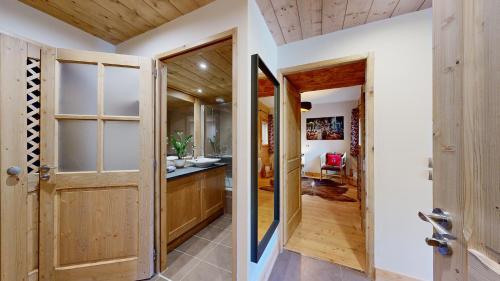 un couloir avec une porte menant à une cuisine dans l'établissement Elégant logement, Superbe vue, à Champagny-en-Vanoise