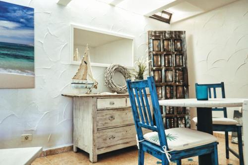 ein Esszimmer mit einem Tisch und blauen Stühlen in der Unterkunft Finca Vino Tinto 4 in Icod de los Vinos