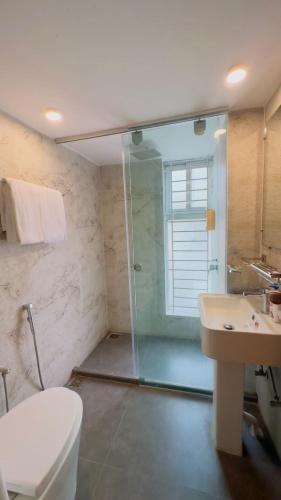 a bathroom with a shower and a toilet and a sink at Priyo Nibash Stylish Residential Hotel in Dhaka