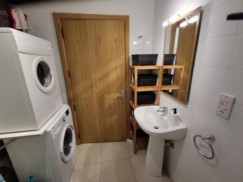 uma casa de banho com uma máquina de lavar roupa e um lavatório em Spinola Bayview Apartment em St. Julian's