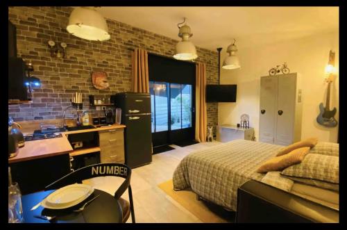 a kitchen and a bedroom with a bed and a sink at Studio Style Industriel avec Terrasse et Parking 