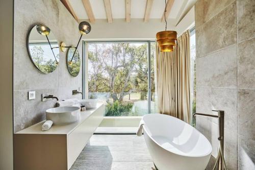 La salle de bains est pourvue de 2 lavabos et d'une grande fenêtre. dans l'établissement Villa Calanque, Saint-Tropez, à Saint-Tropez