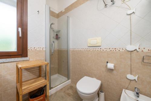 a bathroom with a toilet and a shower and a sink at Villa Bouganville Cala Sinzias in Castiadas