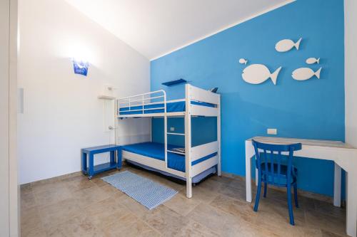 a bunk bed and a desk in a room with a blue wall at Villa Bouganville Cala Sinzias in Castiadas