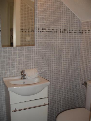 a bathroom with a sink and a toilet and a mirror at Terraced House - Zand Properties in Benidorm